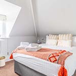 bed decorated with colourful blanket and towels 